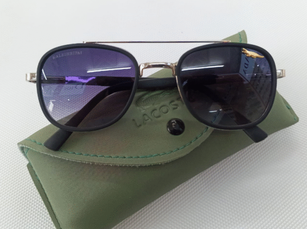 Lacoste square sunglasses with black frames and gradient lenses on a green case
